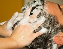 hairdersser massaging hair with shampoo